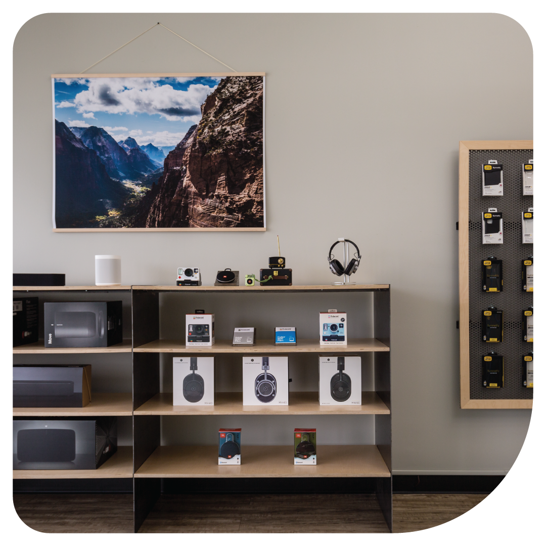 Inside our Fort Collins Apple Repair location. Beats headphones, cameras, and iPhone accessories  in our store with a photo of Fort Collins hanging.